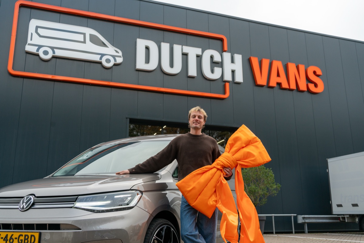 Bedrijfswagen van DutchVans met oranje strik voor het pand