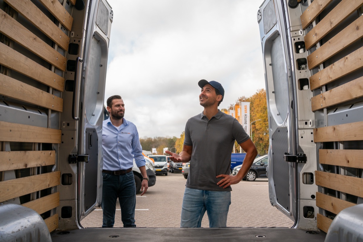 Collega's van DutchVans in gesprek bij een bedrijfswagen